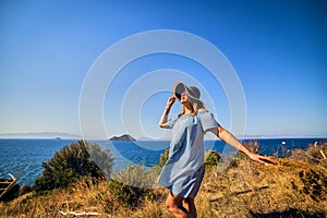 Beautiful woman in beach hat enjoying sea view with blue sky at sunny day in Bodrum, Turkey. Vacation Outdoors Seascape Summer