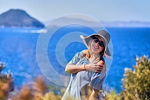 Beautiful woman in beach hat enjoying sea view with blue sky at sunny day in Bodrum, Turkey. Vacation Outdoors Seascape Summer