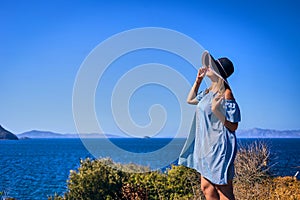 Beautiful woman in beach hat enjoying sea view with blue sky at sunny day in Bodrum, Turkey. Vacation Outdoors Seascape Summer