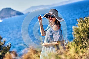 Beautiful woman in beach hat enjoying sea view with blue sky at sunny day in Bodrum, Turkey. Vacation Outdoors Seascape Summer