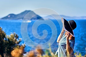 Beautiful woman in beach hat enjoying sea view with blue sky at sunny day in Bodrum, Turkey. Vacation Outdoors Seascape Summer