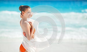 Beautiful woman on the beach in orange bikini