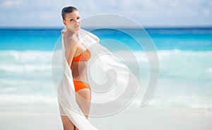 Beautiful woman on the beach in orange bikini