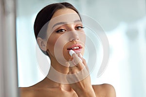 Beautiful Woman With Beauty Face Applies Balm On Lips. Skin Care