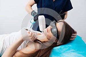 Beautiful woman in beauty studio getting laser hair removal procedure