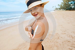 Beautiful Woman in Bikini Applying Sun Cream on Tanned  Shoulder. Sun Protection. Skin and Body Care.