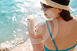 Beautiful Woman in Bikini Applying Sun Cream on Tanned Shoulder. Sun Protection. Skin and Body Care. Girl Using Sunscreen to Skin.