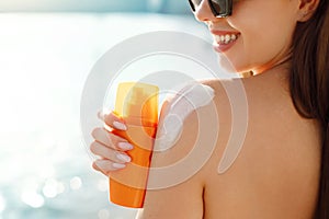 Beautiful Woman in Bikini Applying Sun Cream on Tanned Shoulder. Sun Protection. Skin and Body Care. Girl Using Sunscreen to Skin