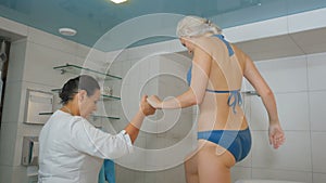 Beautiful woman in bikini finish the hydromassage procedures in salon