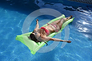 beautiful woman in bikini lying relax on float airbed at vacacti