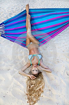 Beautiful, woman in bikini posing on a hammock on the caribbean beach.