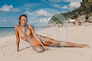 Beautiful woman in bikini relax at tropical ocean beach. Slim woman on beach