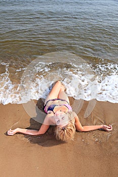 Beautiful woman in bikini sunbathing seaside