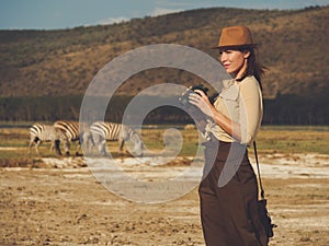 Beautiful woman with binoculars at savanna in Kenya