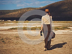 Beautiful woman with binoculars at savanna in Kenya