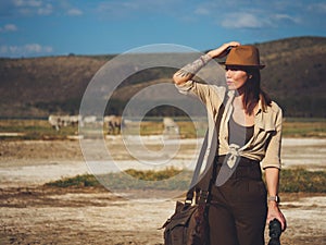 Beautiful woman with binoculars at savanna in Kenya