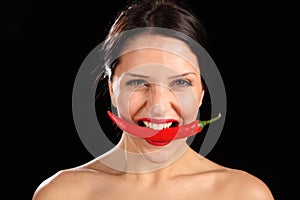 Beautiful woman biting on red chili pepper