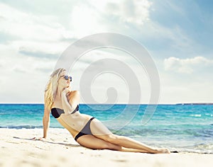 Beautiful woman in black bikini. Young and sporty girl posing on