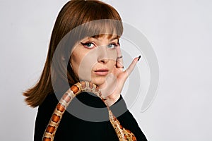 Beautiful woman in black bodywear and snake. Ginger model girl with fashion perfect make up