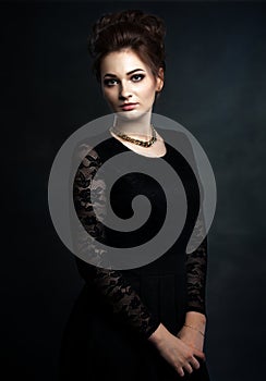 Beautiful woman on black classical dress. Vogue style photo.