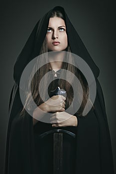 Beautiful woman with black cloak and sword