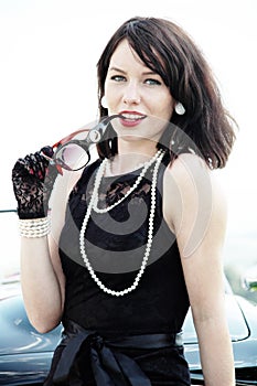 Beautiful woman in black dress and pearl necklace