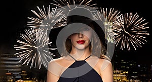 Beautiful woman in black hat over night firework