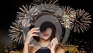 Beautiful woman in black hat over night firework