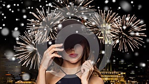 Beautiful woman in black hat over night firework