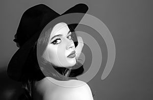 Beautiful woman in black hat. Sensual retro fashion. Isolated. High-fashion portrait.