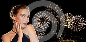 Beautiful woman in black over firework lights