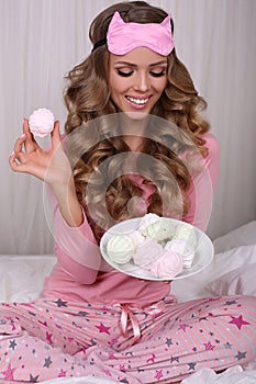 beautiful woman with blond curly hair in pajama with sweets