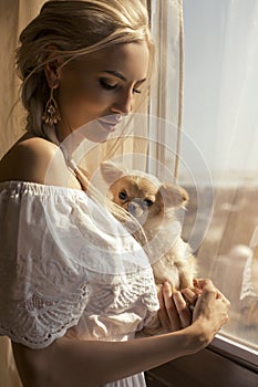 Beautiful woman with blond hair with cute little dog