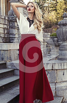 beautiful woman with blond hair in elegant dress at park