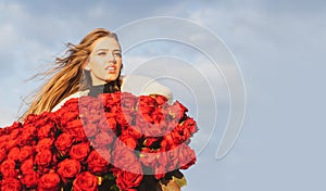 Beautiful woman with blooming rose flowers. Girl with rose bouquet outdoor.