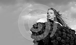 Beautiful woman with blooming rose flowers. Girl with rose bouquet outdoor.