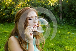 Beautiful woman blowing bubbles in the summe near the lake