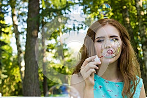 Beautiful woman blowing bubbles in the summer, sunny day