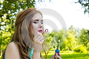 Beautiful woman blowing bubbles in the sun