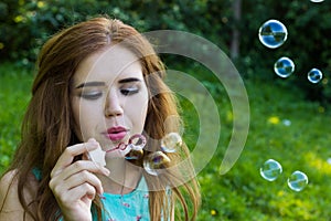 Beautiful woman blowing bubbles in the sun