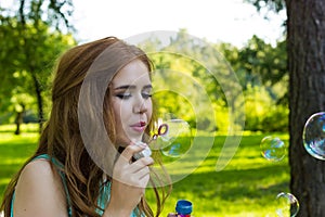 Beautiful woman blowing bubbles in the sun