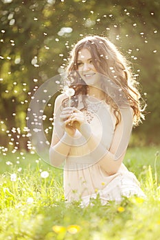 Beautiful woman blowing a dandelion