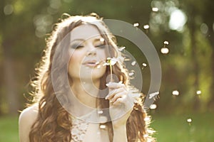 Beautiful woman blowing a dandelion