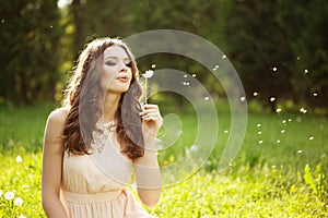 Beautiful woman blowing a dandelion