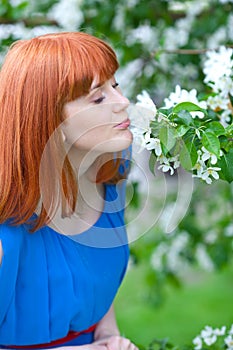 Beautiful woman in blue dress near apple tree