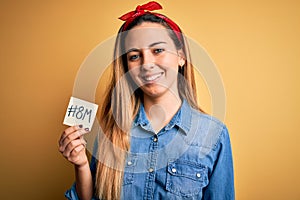 Beautiful woman with blue eyes celebrating 8th march womens day holding reminder paper with a happy face standing and smiling with