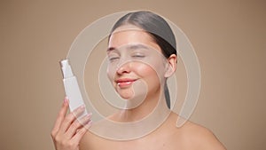 Beautiful woman with bottle of moisturizer cream