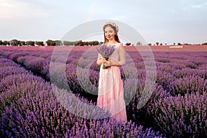 Beautiful woman with a bouquet of lavender in a lavender field