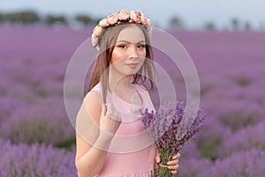 Beautiful woman with a bouquet of lavender in a lavender field