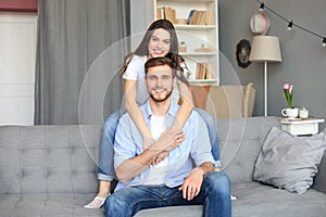 Beautiful woman with boyfriend spending quality time together on sofa at home in the living room